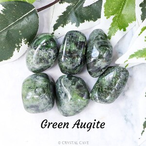 May include: Six smooth, green Augite tumbled stones. The stones are a dark green with black and white streaks. Green Augite is a grounding stone that can help with emotional stability.