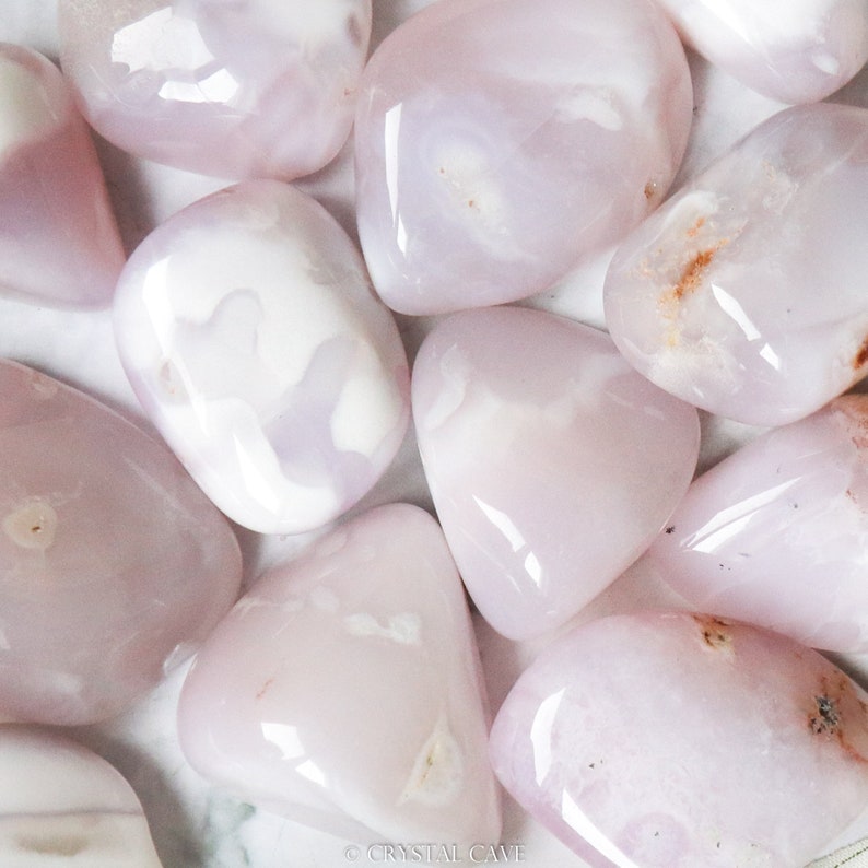 Pode incluir: Uma cole&ccedil;&atilde;o de pedras de &aacute;gata rosa e branca polidas. As pedras s&atilde;o lisas e polidas, com uma variedade de padr&otilde;es e texturas.