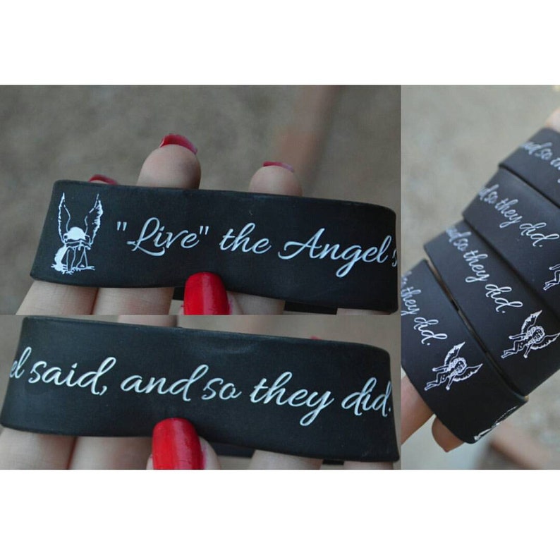 May include: Black rubber bracelets with white text and an angel graphic. The text on the bracelets reads "Live" the Angel" and "I said, and so they did."