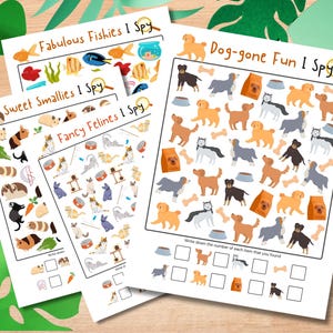May include: A collection of four white paper activity sheets with colorful illustrations. The sheets feature the titles "Fabulous Fishies I Spy", "Sweet Smallies I Spy", "Fancy Felines I Spy", and "Dog-gone Fun I Spy". Each sheet has a different theme with various objects to find.