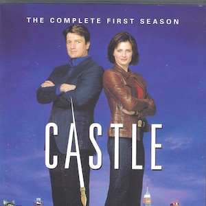 May include: A DVD cover for the first season of the TV show "Castle". The cover features a man and a woman standing in front of a cityscape. The man is wearing a suit and the woman is wearing a leather jacket. The title "Castle" is written in large white letters across the middle of the cover. The tagline "A whole new chapter in crime solving." is written at the bottom of the cover.