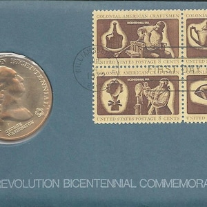 Puede incluir: Una medalla de color dorado con la inscripción "American Revolution Bicentennial 1776-1976" y un retrato de George Washington. La medalla se muestra sobre un fondo azul con cuatro sellos postales que representan a artesanos coloniales estadounidenses.