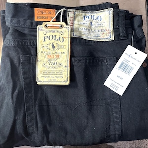 May include: Black Polo Ralph Lauren bootcut jeans, size 38x30, with attached tags. The tags display the Polo logo, brand information, and the text "Original RL Quality". The jeans have a classic five-pocket design.