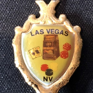 Las Vegas, Nevada com caça-níqueis, dados e cartas (parte superior) em uma colher de lembrança recortada dourada - usada