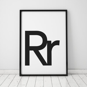 May include: Black and white framed print with the letters "Rr" in a bold, sans-serif font.