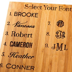 May include: A wooden board with nine different font styles to choose from for a personalized gift. The fonts include cursive, block, and monogram styles. The text on the board reads "Select Your Font".