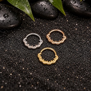 May include: Three circular hoop rings featuring a scalloped edge design with small bead accents. The set includes one silver-toned ring, one rose gold-toned ring, and one gold-toned ring, each with a hinged segment for closure and wear.
