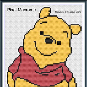 May include: A pixel art pattern of Winnie the Pooh, a cartoon bear, wearing a red shirt. The pattern is in a frame and has the text "Pixel Macrame" and "Copyright © Pegasus Signs".