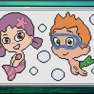 May include: Cross-stitch artwork featuring two cartoon characters, a mermaid with purple hair and a boy with orange hair and goggles. The mermaid has a pink tail and the boy has a green fin. Bubbles surround the characters.