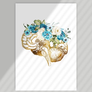 Op de afbeelding: Een goudkleurige illustratie van een menselijk brein versierd met blauwe en witte bloemstukken. Het kunstwerk is geplaatst tegen een witte achtergrond, wat een opvallend contrast cre&euml;ert. De details van de hersenen worden benadrukt met goud, en de bloemen voegen elegantie toe.
