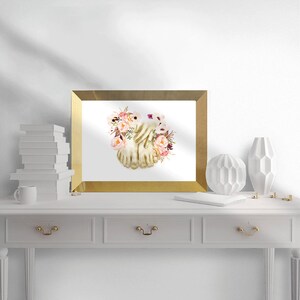 May include: A framed print of a watercolor painting of two bare feet intertwined with pink and purple flowers.