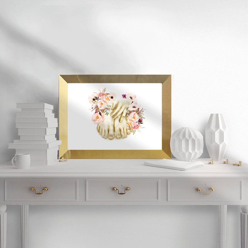 May include: A framed print of a watercolor painting of two bare feet intertwined with pink and purple flowers.