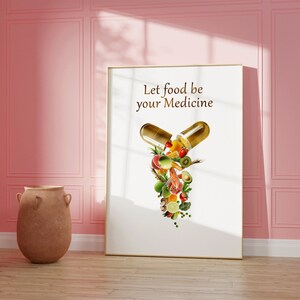 May include: A white framed poster with the text "Let food be your medicine" and a graphic of a golden capsule with various fruits and vegetables spilling out.