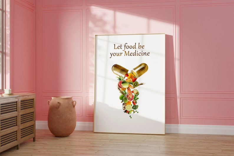 May include: A white framed poster with the text "Let food be your medicine" and a graphic of a golden capsule with various fruits and vegetables spilling out.
