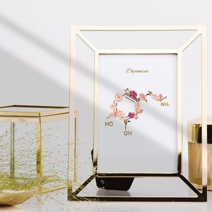 Pode incluir: Uma moldura dourada com fundo branco e uma ilustra&ccedil;&atilde;o floral da estrutura qu&iacute;mica da dopamina. O texto "Dopamine" est&aacute; escrito no topo da imagem.