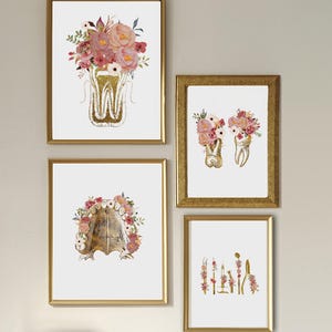 May include: Four framed wall art prints featuring gold-toned anatomical dental illustrations adorned with watercolor floral arrangements in shades of pink, red, and green. The prints depict a tooth, two teeth, a dental arch, and dental tools.