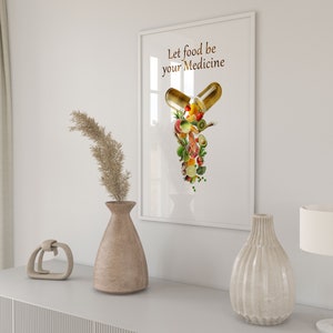 May include: A white framed print with the text "Let food be your medicine" and a graphic of a capsule filled with various fruits and vegetables.