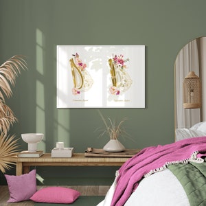 May include: A white framed print with two gold harp silhouettes decorated with pink and white flowers. The print is hanging on a sage green wall above a wooden bench with pink pillows.