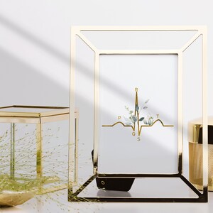 May include: Gold-toned metal picture frame with a white background and a gold EKG graphic with the letters P, Q, R, S, and T. The EKG graphic is accented with a watercolor floral design.