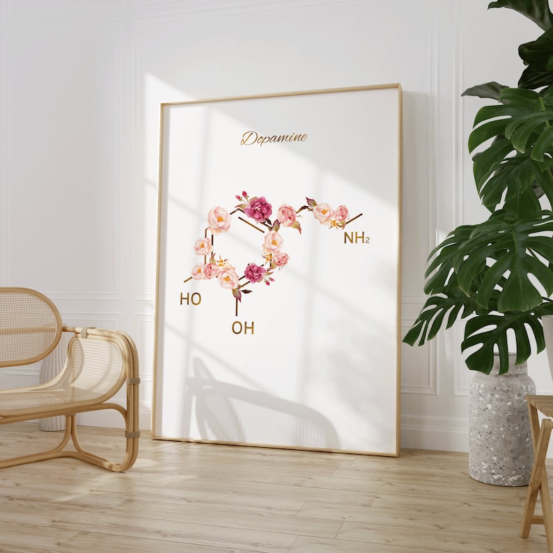 Pode incluir: Um cartaz branco com a palavra "Dopamina" em letras douradas. A estrutura qu&iacute;mica da dopamina &eacute; representada por flores cor-de-rosa e brancas.
