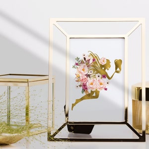May include: A gold picture frame with a white background and a gold silhouette of a fairy holding a tooth. The fairy is surrounded by pink and purple flowers.