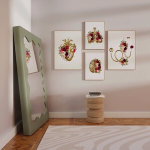 May include: Four framed prints with anatomical illustrations of the heart, lungs, brain, and a stethoscope, all decorated with floral arrangements in shades of burgundy, pink, and white.