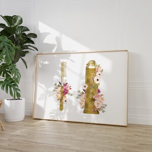 May include: Gold-toned illustration of a tube of toothpaste and a toothbrush with floral accents. The toothpaste tube says "Tooth Paste" and the floral accents are in shades of pink, white, and green.