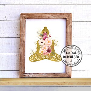 Op de afbeelding: Een digitale print met een gouden silhouet van een mediterende Boeddha met roze en witte bloemen. De print is ingelijst in een rustiek houten frame.