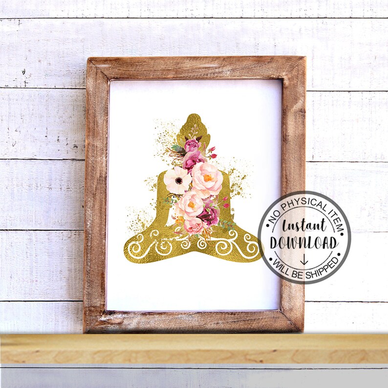 Op de afbeelding: Een digitale print met een gouden silhouet van een mediterende Boeddha met roze en witte bloemen. De print is ingelijst in een rustiek houten frame.