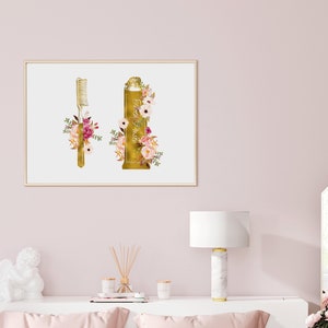May include: A gold-colored toothbrush and tube of toothpaste with floral accents. The toothbrush and toothpaste are surrounded by pink, white, and green flowers.