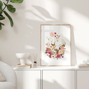 May include: A framed print of a watercolor illustration of a heart with pink and white flowers. The heart is surrounded by leaves and flowers in shades of pink, white, and green.