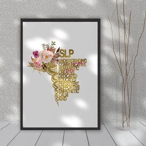 May include: A white framed print with a gold floral design and the word "SLP" in gold letters. The word "SLP" is surrounded by words describing the qualities of a speech-language pathologist, such as "understanding", "communicative", "humanistic", "creative", "dedicated", "educated", "persistent", "supportive", "empathetic", "calm", and "kind".
