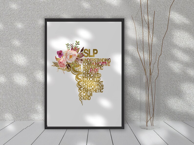 May include: A white framed print with a gold floral design and the word "SLP" in gold letters. The word "SLP" is surrounded by words describing the qualities of a speech-language pathologist, such as "understanding", "communicative", "humanistic", "creative", "dedicated", "educated", "persistent", "supportive", "empathetic", "calm", and "kind".