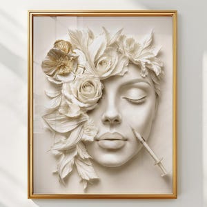 Op de afbeelding: Een digitale kunstdruk in een gouden lijst met een wit gebeeldhouwd gezicht, aan één kant versierd met witte en gouden bloemen. Een kleine medische injectiespuit is bij de wang van het gezicht geplaatst. De tekst DIGITAL DOWNLOAD is rechtsboven zichtbaar.