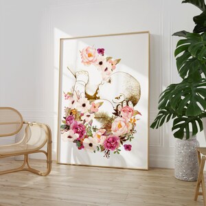 May include: A gold outline of a baby in a fetal position surrounded by a wreath of pink, white, and purple flowers.