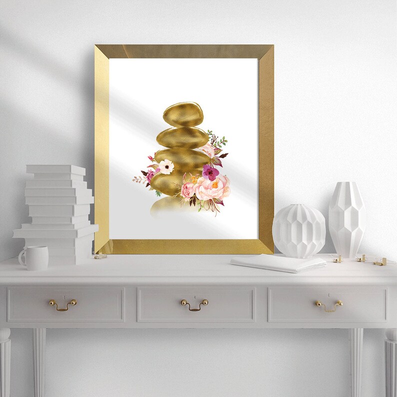 May include: A gold-toned zen stone stack with pink and purple flowers, a watercolor illustration in a gold frame.