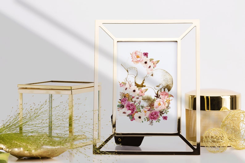 May include: A gold-toned picture frame with a white mat and a watercolor print of a baby surrounded by pink and white flowers.