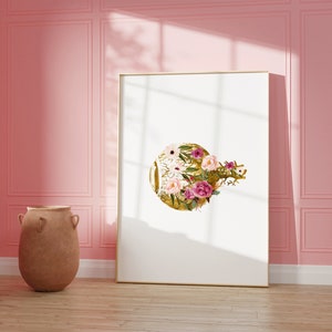 May include: A framed print with a gold circle design featuring pink and white flowers. The print is hanging on a pink wall.