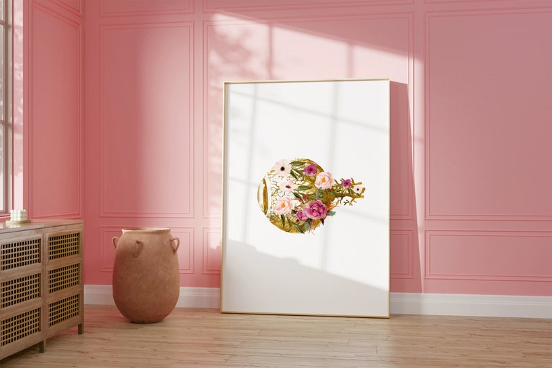 May include: A framed print with a gold circle design featuring pink and white flowers. The print is hanging on a pink wall.