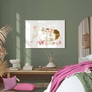 May include: A watercolour painting of a woman with a floral crown sleeping on a white background. The painting is framed and hanging on a green wall in a bedroom setting.