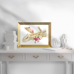 K&ouml;nnte beinhalten: Eine Aquarell-Illustration einer Person, die eine Beinmassage erh&auml;lt. Die Illustration ist in Goldt&ouml;nen mit rosa und burgunderfarbenen Blumen gehalten.