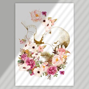 May include: A gold silhouette of a baby in utero surrounded by pink, white, and purple watercolor flowers.