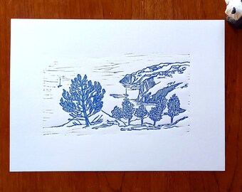 May include: A blue ink drawing of a landscape with a large tree in the foreground and a mountain range in the background.