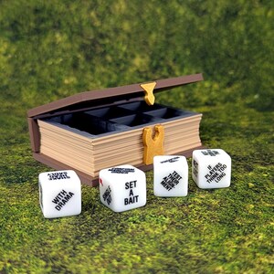 May include: A brown wooden box with a book-like design, open to reveal compartments. Four white dice with black text are in front of the box. The dice read "WITH DRAMA", "SET A BAIT", "TEST YOUR MIGHT", and "IF PLAYERS THINK TOO LONG".