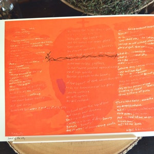 Könnte beinhalten: Ein orangefarbener Kunstdruck mit weißem Text und einer stilisierten Apfelform. Der Druck zeigt handgeschriebene Poesie und den Titel "Jesus of the City". Eine schwarze Linie mit Dornen ist über den Apfel gezeichnet.