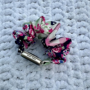 May include: A floral patterned fabric watch band with a gold Apple Watch.