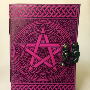 May include: A pink leather journal with a black pentacle design and a Celtic knot border. The journal has a brass clasp.