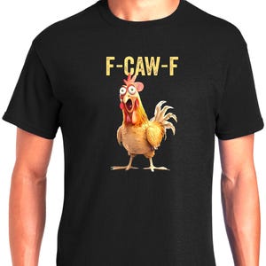 May include: Black t-shirt featuring a cartoon chicken with an open beak and wide eyes. The text "F-CAW-F" is printed above the chicken in a yellow, distressed font. The chicken is depicted in shades of yellow, orange, and brown.