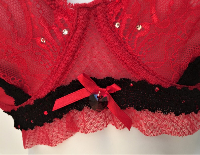 May include: Red lace lingerie with black lace trim and a red satin bow with a rhinestone embellishment.