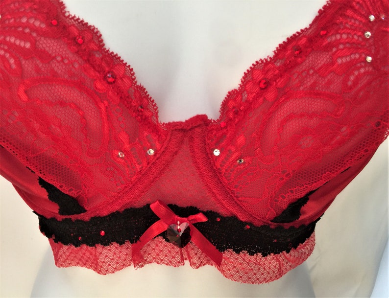 May include: Red lace bra with black trim and rhinestones.